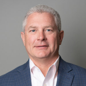Steve Hirsch in a professional headshot, wearing a blue plaid suit jacket and white dress shirt.