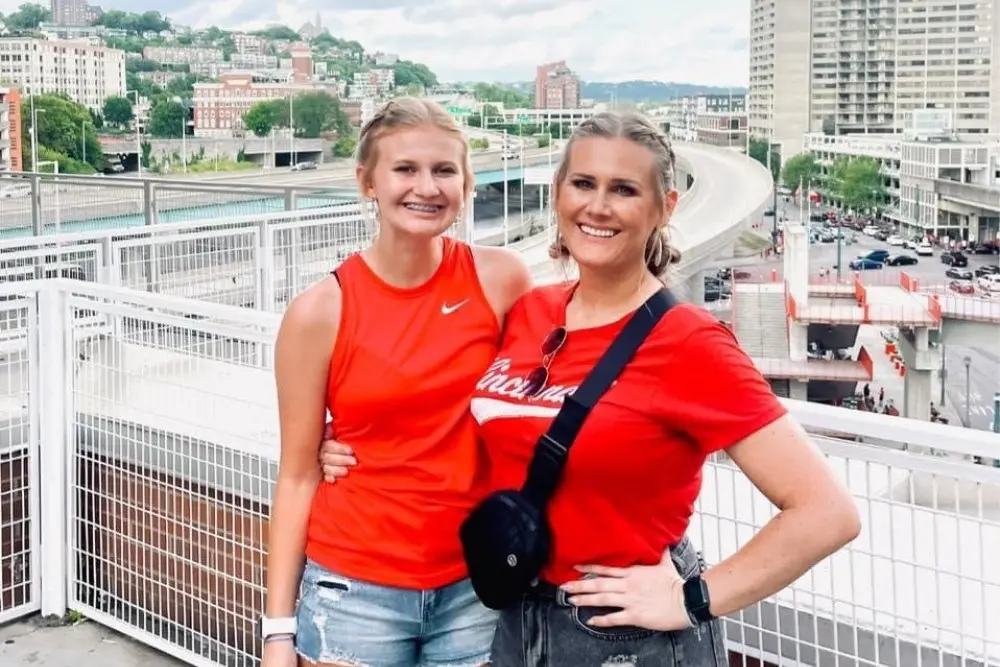 Krista Depugh Adena midwife patient Krista Depugh poses with a young girl on an urban overlook with city buildings and highways in the background.
