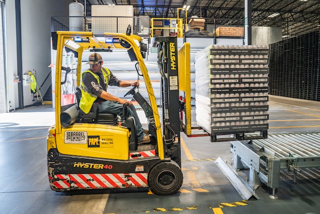 Man in warehouse driving forklift