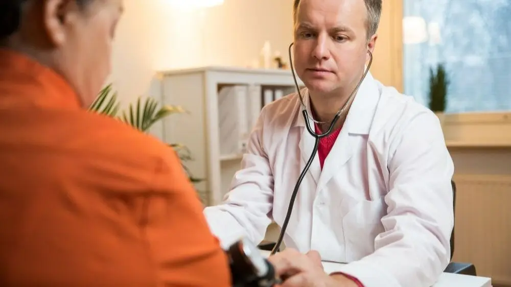 stock-photo-smiling-elderly-patient-grateful-for-help-of-a-doctor-in-white-uniform-fixing-his-hand-768825655