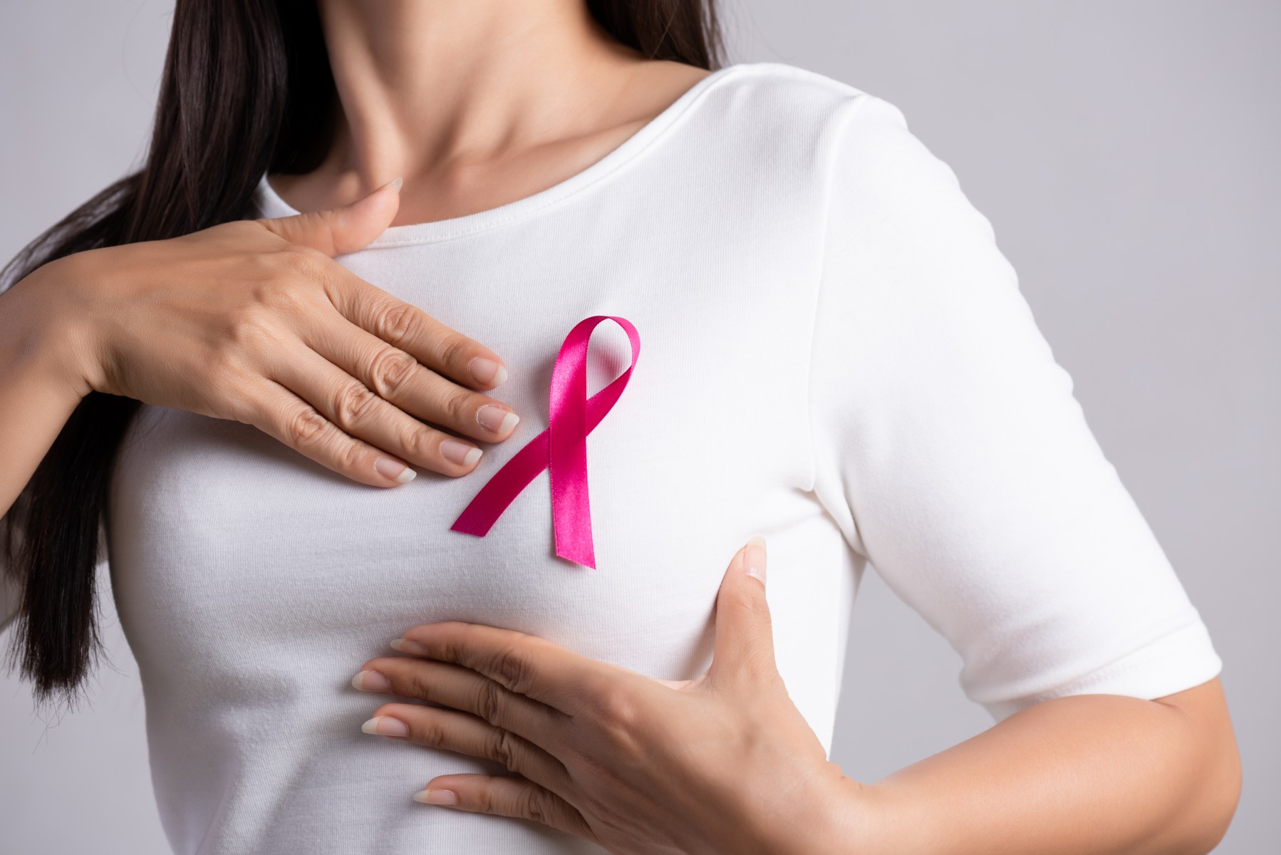 A woman checking her breast, for breast cancer awareness.