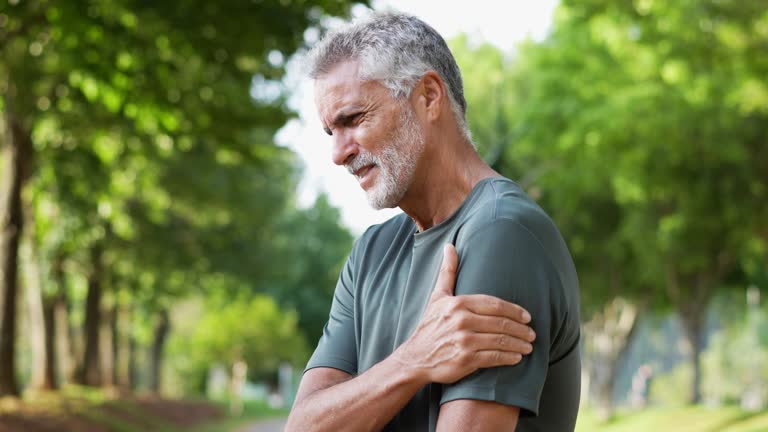 A older man, suffering from shoulder pain while working out.