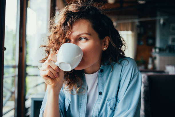 A young lady drinking her morning cup of coffee.