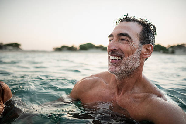 An older man still swimming even though he has an enlarged prostate.
