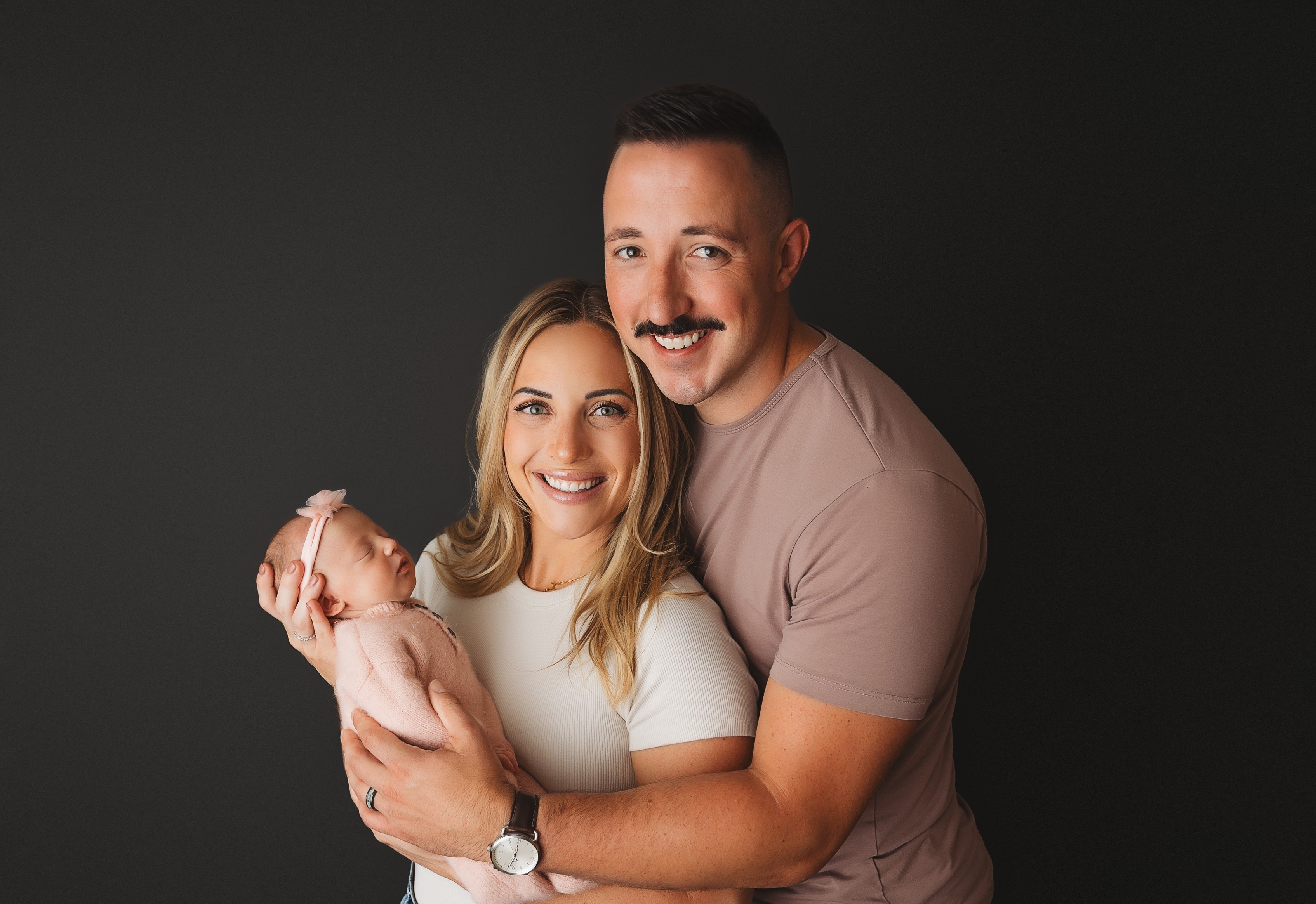 Katie Mong and her husband holding her baby.