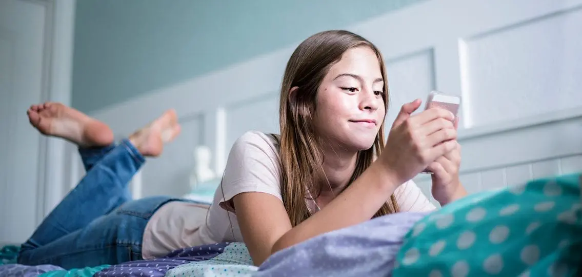 Teen scrolling on her cell phone.